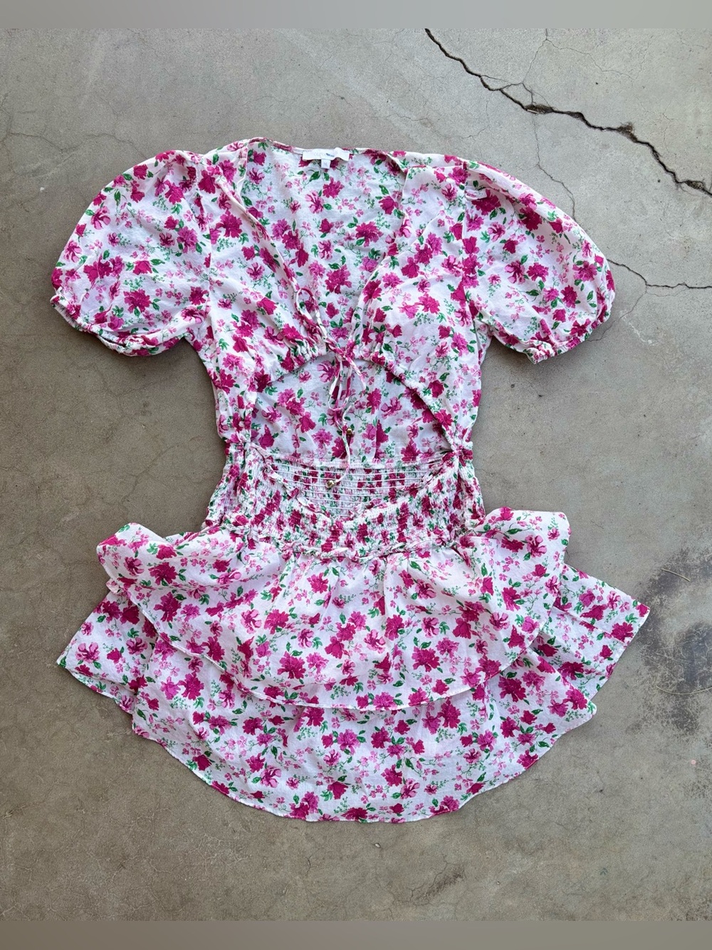 100% cotton pink floral dress with ruffle hem and peekaboo tie front. Size M